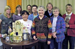 A few members of the St. Gregory's Women's Ministry are shown standing behind an example of a home altar. (Angie DelMoral)