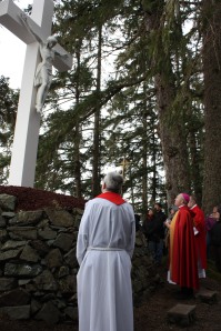 Bishop Burns blesses the outdoor cross at the Shrine of St. Therese following the annual Good Friday Stations of the Cross service.