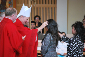 Bishop Edward Burns confirms a young woman at St. Paul the Apostle Church in Juneau, May of 2011.