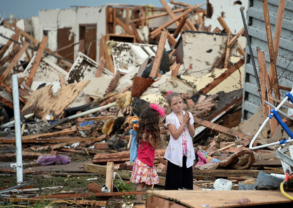 Two girls stand in rubble after a tornado struck Moore, Okla., May 20. The mile-wide tornado touched down near Oklahoma City, killing dozens, including many children, destroying homes, businesses and a pair of elementary schools in the suburb of Moore. (CNS photo/Gene Blevins, Reuters)