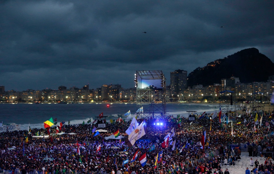 Pilgrims wait for the arrival of Pope Francis at the World Youth Day welcome ceremony on Copacabana beach in Rio de Janeiro July 25. (CNS photo/Paul Haring) (July 26, 2024)