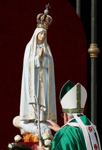 Pope Francis touches the original statue of Our Lady of Fatima at the start of a Mass in honor of Mary in St. Peter's Square at the Vatican Oct. 13. The pope entrusted the world to Mary at the end of the Mass. (CNS photo/Paul Haring) 