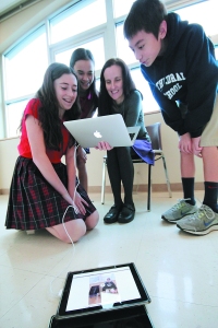 Erin Foley, Sofia Mercado, teacher Liane Rae and Hanjin Jacobs work on a science skit using an iPad at Cathedral School in late December 2013 Portland, Ore. Cathedral is one of an increasing number of Catholic schools that give an iPad or tablet to every student. (CNS photo/Ed Langlois, Catholic Sentinel) (Jan. 29, 2014)
