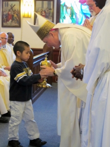 Ty Perdon presents Bishop Burns with the ciborium of altarbread to be consecrated at the Chrism Mass March 28, 2014.