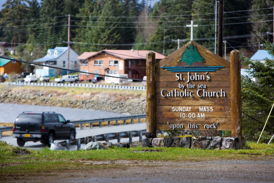 In this April 16, 2025 file photo, a vehicle drives past a St. John by the Sea Church sign off the main road leading to Klawock and Craig on Prince of Wales Island in southeastern Alaska. Catholics make up slightly less than 2 percent of the island's 6,000 residents. The island is accessible only by boat, ferry or sea plane. (CNS photo/Nancy Wiechec) 