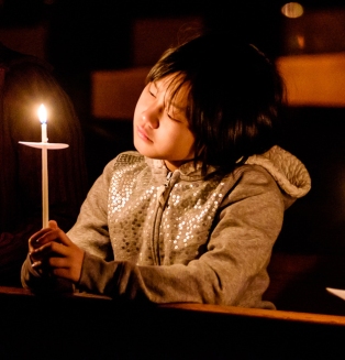 Young people hold candles during Easter Vigil at Connecticut cathedral